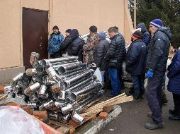Lugareños reciben pequeñas estufas de leña en la aldea de Tsyrkuny, cerca de Kharkiv, Ucrania, por parte de voluntarios. EFE/S. Kozlov