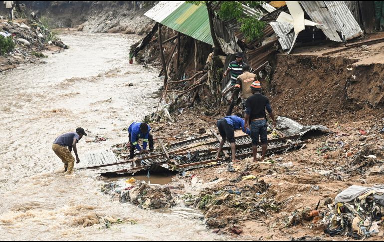 Un grupo de hombres rescatan partes de su hogar destruido por el ciclón en el sur de Malaui. AP