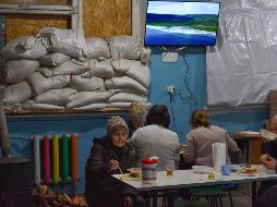 Residentes locales comen gratis en un refugio cerca del frente en la ciudad de Orekhovo, Ucrania. AP/A. Andriyenko
