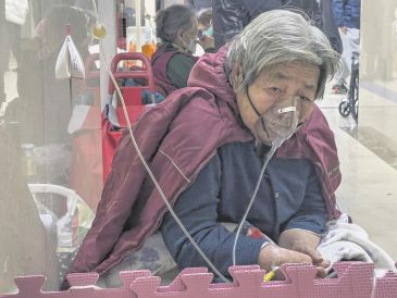 Una paciente está conectada a un ventilador en el pasillo de la sala de emergencias de un hospital en Beijing. La repentina reapertura de China dejó a las personas mayores vulnerables. AP