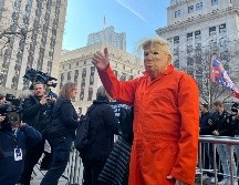 Un hombre, vestido con el uniforme carcelario y una máscara de Trumo, saluda durante la concentración en la plaza Collect Pond Park, aledaña al tribunal donde comparece el expresidente de EU. EFE / S. Yáñez-Richards