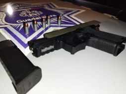 Policías localizaron al interior del vehículo una pistola aparentemente calibre .9 milímetros con cinco cartuchos útiles. ESPECIAL