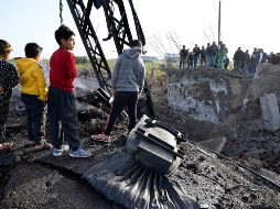 Niños libaneses miran los restos de un puente destruido por los ataques israelíes en Alqulaylah. EFE/W. Hamzeh