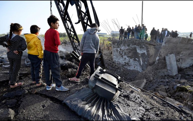 Niños libaneses miran los restos de un puente destruido por los ataques israelíes en Alqulaylah. EFE/W. Hamzeh