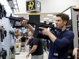 Un miembro de la NRA posa con un arma del tipo AR-15 durante la conferencia anual en Indianápolis, Indiana, celebrada este fin de semana. REUTERS