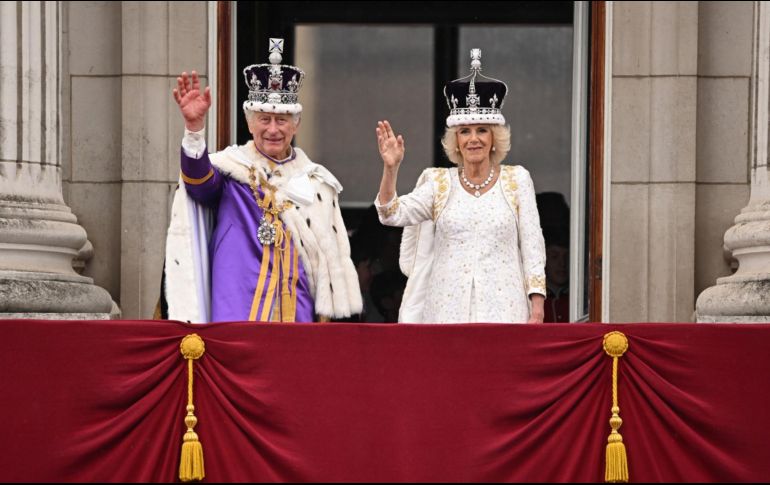 Carlos III y la reina Camila salieron el sábado al balcón del Palacio de Buckingham para saludar a las decenas de miles de personas allí congregadas para celebrar su coronación. AFP / O. Scarff
