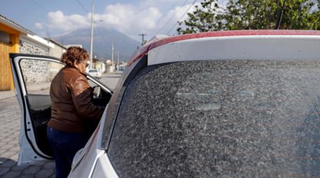Una mujer aborda su auto cubierto de ceniza ante las continuas exhalaciones del volcán Popocatépetl, en la comunidad de San Pedro Benito Juárez, Puebla.  EFE / H. Ríos