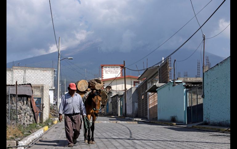 Una persona camina por una calle ante las continuas exhalaciones del volcán Popocatépetl. EFE / H. Ríos
