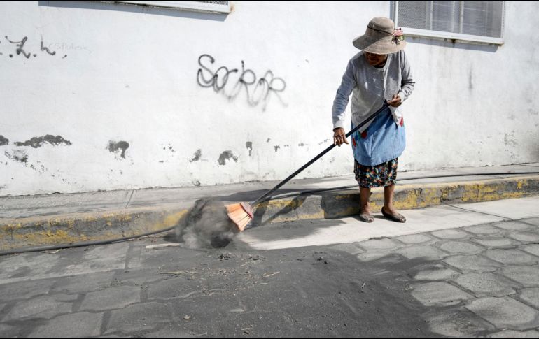 Una habitante barre la ceniza de las calles ante las continuas exhalaciones del volcán Popocatépetl, en la comunidad de San Pedro Benito Juárez, Puebla. EFE / H. Ríos