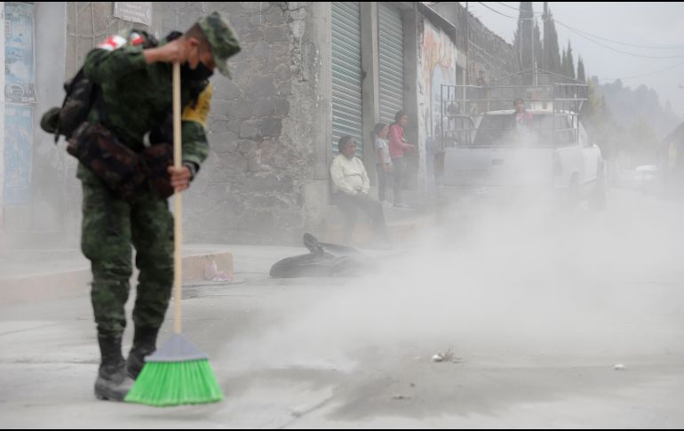 Integrantes del Ejército mexicano barren la ceniza tras las continuas exhalaciones del volcán Popocatépetl. EFE / H. Ríos