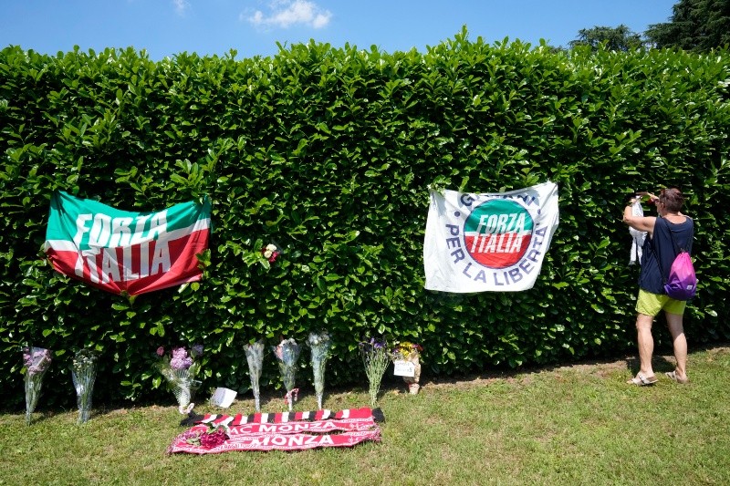 Seguidores dejan mensajes de recuerdo con banderas de Italia y de su partido, Forza Italia. AP/A. Calanni