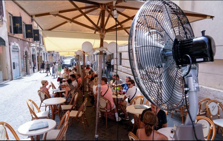Clientes disfrutan del alivio de un ventilador mientras se sientan en un bar en Roma. Con 34 grados Celsius, las temperaturas en Italia están alcanzando rápidamente los promedios altos del verano que inicia hoy. AP / A. Medichini