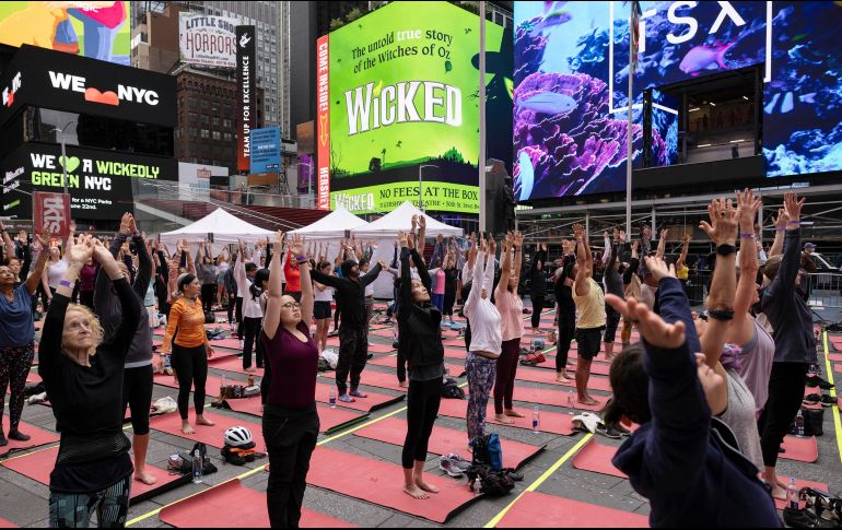 La gente participa en una clase de yoga durante el evento 