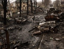 Una mujer camina entre tanques rusos destruidos en Bucha, en las afueras de Kiev, Ucrania, el domingo 3 de abril de 2022. AP / R. Abd