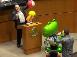 Gabriel Hernández exhibió la imitación de dinosaurio verde y, sin mencionar a Xóchitl Gálvez, dijo que éste recibió contratos por mil 472 millones de pesos. ESPECIAL