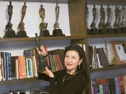 La actriz y presidente de la Academia Mexicana de Artes y Ciencias Cinematográficas Leticia Huijara, posa junto a diversas estatuillas del Ariel. AFP