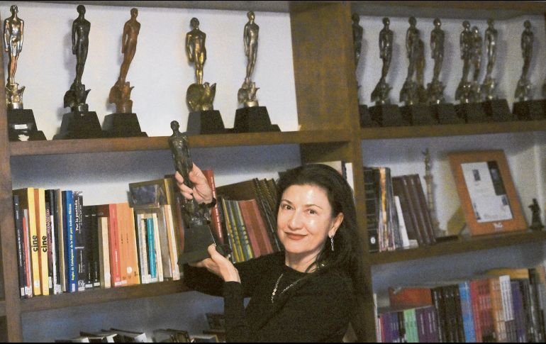 La actriz y presidente de la Academia Mexicana de Artes y Ciencias Cinematográficas Leticia Huijara, posa junto a diversas estatuillas del Ariel. AFP