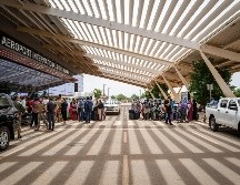 Ciudadanos extranjeros hacían fila hoy ante un aeropuerto en la capital de Níger y esperaban salir del país a bordo de un avión militar francés, mientras un grupo regional seguía negociando su respuesta al golpe militar. AFP / J. Sarago