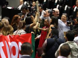 Los legisladores del PRI tomaron la tribuna portando pancartas que expresaban: