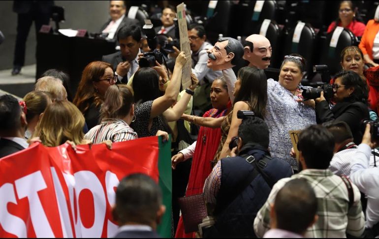 Los legisladores del PRI tomaron la tribuna portando pancartas que expresaban: