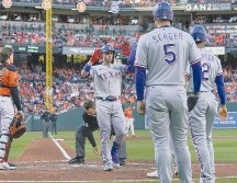 Adley Rutschman, izquierda, receptor de los Orioles de Baltimore, observa cómo Mitch Garver, centro, de los Rangers de Texas, celebra mientras cruza el plato. AP