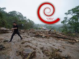 Un hombre cruza una carretera bloqueada por un deslizamiento de tierra provocado por el huracán 