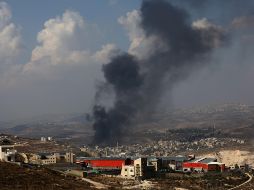 El humo se eleva sobre la ciudad de Deir Sharaf después de que colonos israelíes atacaran la aldea e incendiaran coches y tiendas palestinas. EFE/A. Badarneh