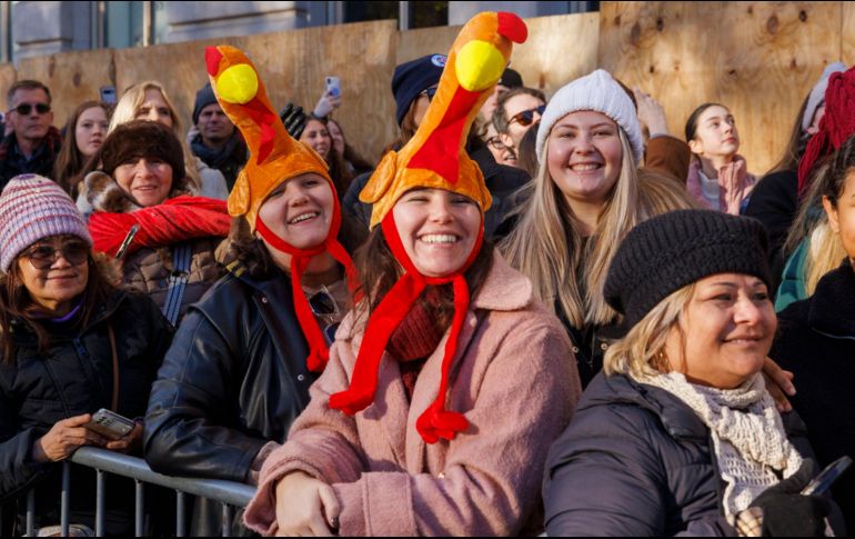 Espectadores con sombreros con temática del pavo observan el desfile. EFE / S. Yenesel