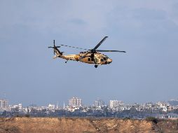 Un helicóptero israelí vuela mientras el humo se eleva desde el sur de Gaza. EFE/A. Safadi