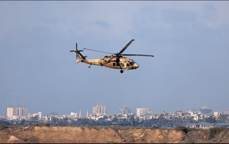Un helicóptero israelí vuela mientras el humo se eleva desde el sur de Gaza. EFE/A. Safadi
