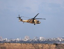 Un helicóptero israelí vuela mientras el humo se eleva desde el sur de Gaza. EFE/A. Safadi