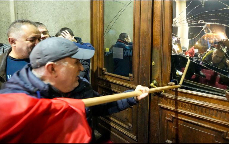 Partidarios de la oposición intentan irrumpir en el ayuntamiento de Belgrado en protesta por presuntas irregularidades en la victoria electoral del Partido Progresista Serbio el domingo pasado. AP/D. Vojinovic