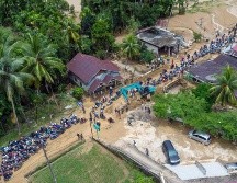 Toneladas de lodo, piedras y árboles derribados de raíz rodaron cuesta abajo en una montaña la noche de ayer viernes, hasta llegar a un río que se desbordó. AFP / M. Kayo