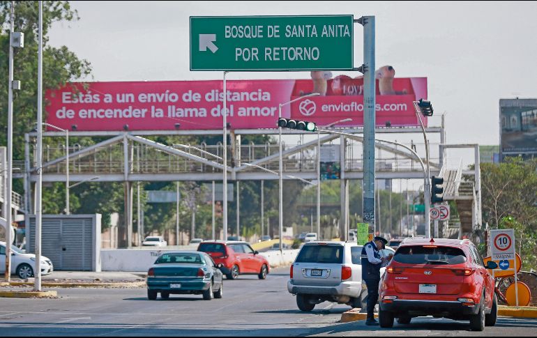 Un agente vial se encuentra tomando datos de un conductor antes del cruce de un semáforo. EL INFORMADOR/ Archivo