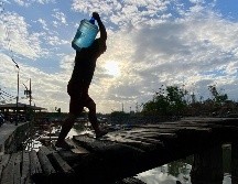 Un hombre carga un recipiente con agua en una aldea de Filipinas. La ONU estima que alrededor de 2 mil 200 millones de personas no tienen acceso a agua potable segura. EFE/F. Malasig