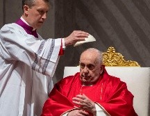 Monseñor Krzysztof Marcjanowicz coloca el casquete al Papa Francisco durante la liturgia de la pasión del Viernes Santo en la Basílica de San Pedro del Vaticano. AP