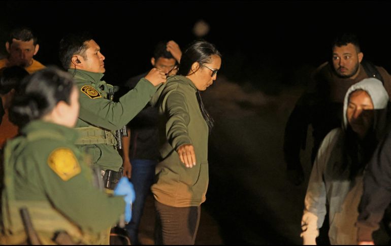 La Patrulla Fronteriza de Estados Unidos revisa a una migrante cerca de la valla fronteriza entre Estados Unidos y México. AFP