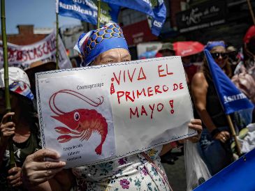 Una mujer sostiene una pancarta con la frase "Viva el primero de mayo" durante una manifestación en el Día Internacional de los Trabajadores. EFE