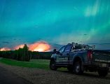 Esta imagen proporcionada por el Ministerio de Agua, Tierras y Gestión de Recursos muestra un incendio forestal, con una aurora boreal sobre el, cerca de Fort Nelson, Canadá, el sábado 11 de mayo de 2024. AP.