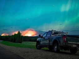 Esta imagen proporcionada por el Ministerio de Agua, Tierras y Gestión de Recursos muestra un incendio forestal, con una aurora boreal sobre el, cerca de Fort Nelson, Canadá, el sábado 11 de mayo de 2024. AP.