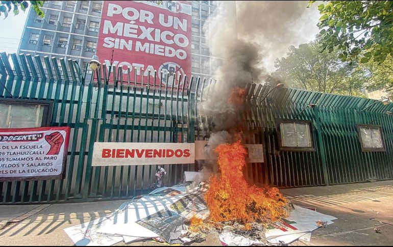 Para mostrar su descontento con el partido tricolor, los maestros juntaron la publicidad política y le prendieron fuego en la puerta principal del edificio del Revolucionario Institucional. EL UNIVERSAL