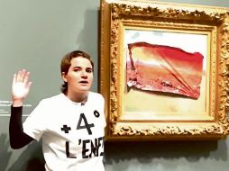 Esta fotografía muestra a un miembro del colectivo Riposte Alimentaire posando después de cubrir el cuadro de Claude Monet “Les Coquelicots” con una pegatina. AFP