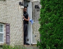 Un miembro del Departamento de Policía de Florence, Kentucky, frente a la puerta de una casa que fue escenario de un tiroteo, el sábado 6 de julio de 2024, en Florence, Kentucky. (AP Foto/Carolyn Kaster)