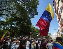 Un hombre agita una bandera de Venezuela en una concentración de venezolanos con motivo de las elecciones presidenciales en su país, este domingo en Cali, Colombia. EFE/ E. Guzmán