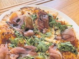 Pizza ferrara, con prosciutto, arúgula, manzana caramelizada y un serpentín de reducción de vinagre balsámico. CORTESÍA