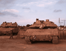 Soldados israelíes, junto a tanques, esperando transporte después de un día de entrenamiento en el centro de los Altos del Golán. EFE / A. Safadi