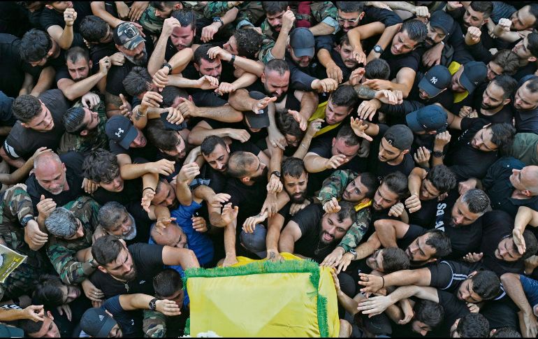 Militantes de Hezbolá se agolpan junto al féretro de uno de sus integrantes fallecidos por el ataque. EFE