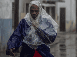Un hombre camina entre el viento y la lluvia provocados por el huracán 