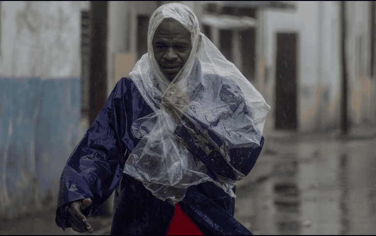 Un hombre camina entre el viento y la lluvia provocados por el huracán 