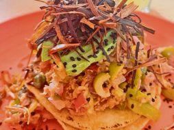 Tostada vizcaína, con de atún estofado con alcaparras, aceitunas, cebolla, jitomate, aguacate y poro. CORTESÍA